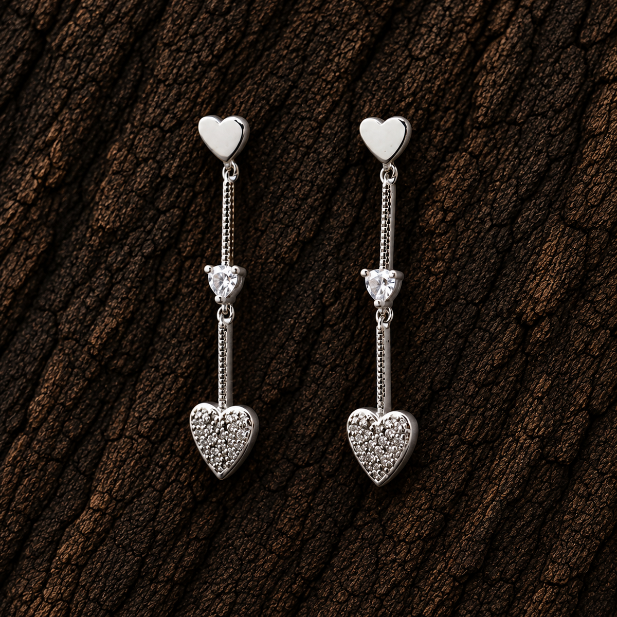 925 sterling silver double heart drop earrings with sparkling CZ accents displayed on dark wood background.