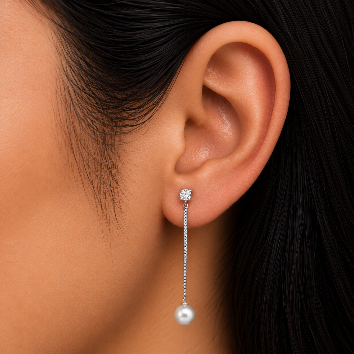 Model wearing 925 sterling silver long drop earrings with clear CZ and white pearl detail.