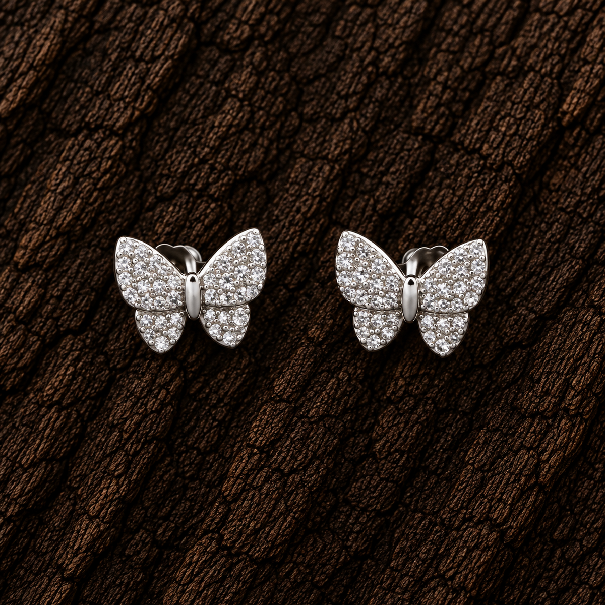 925 sterling silver CZ butterfly stud earrings displayed on dark wood background.