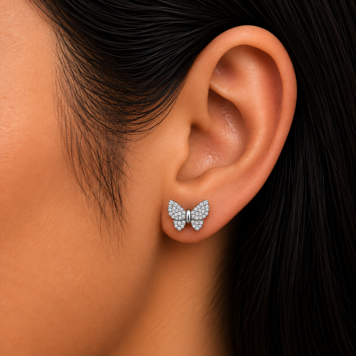 Model wearing 925 sterling silver butterfly stud earrings with sparkling clear cubic zirconia.