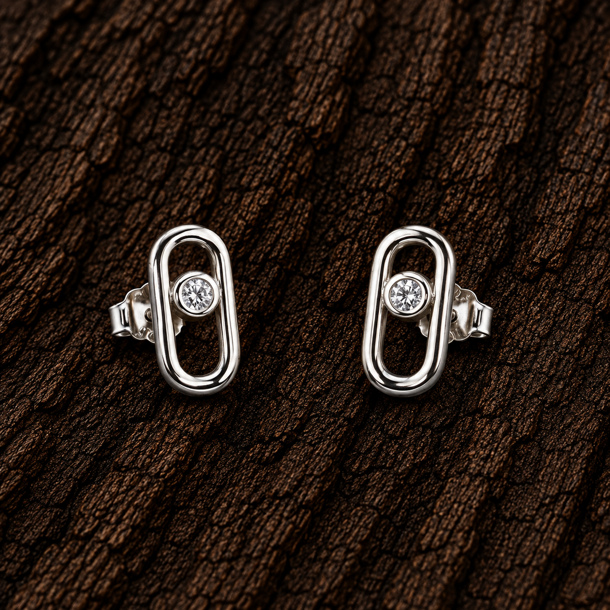 925 sterling silver open oval CZ stud earrings displayed on dark wood background.