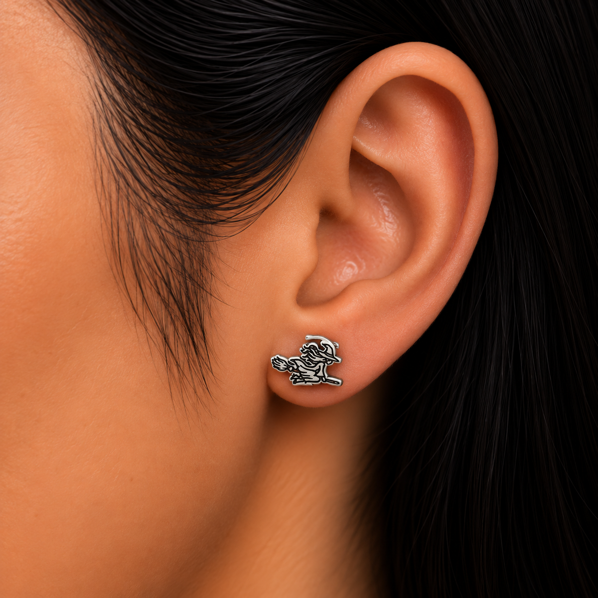Model wearing 925 sterling silver witch on broom stud earring.