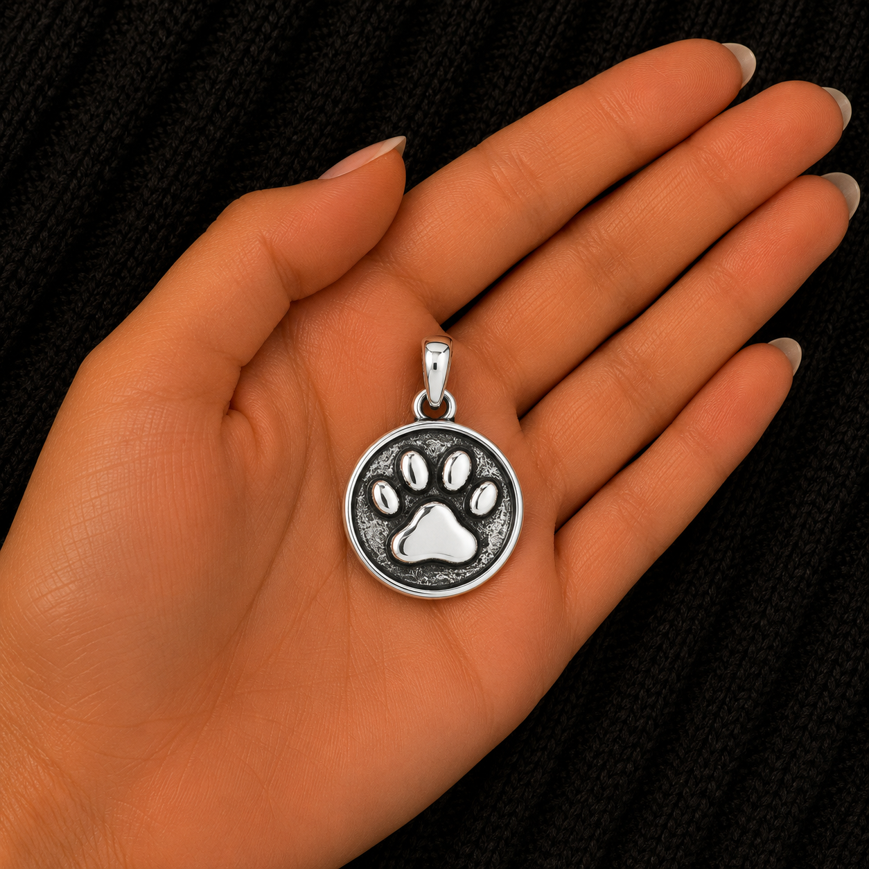 925 Sterling Silver Paw Print Pendant shown in hand for size reference