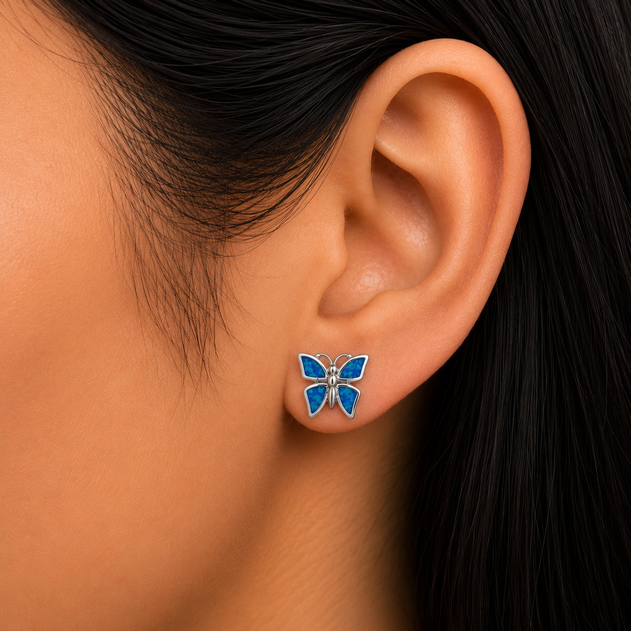 Woman wearing 925 Sterling Silver Blue Lab Opal Butterfly Stud Earrings