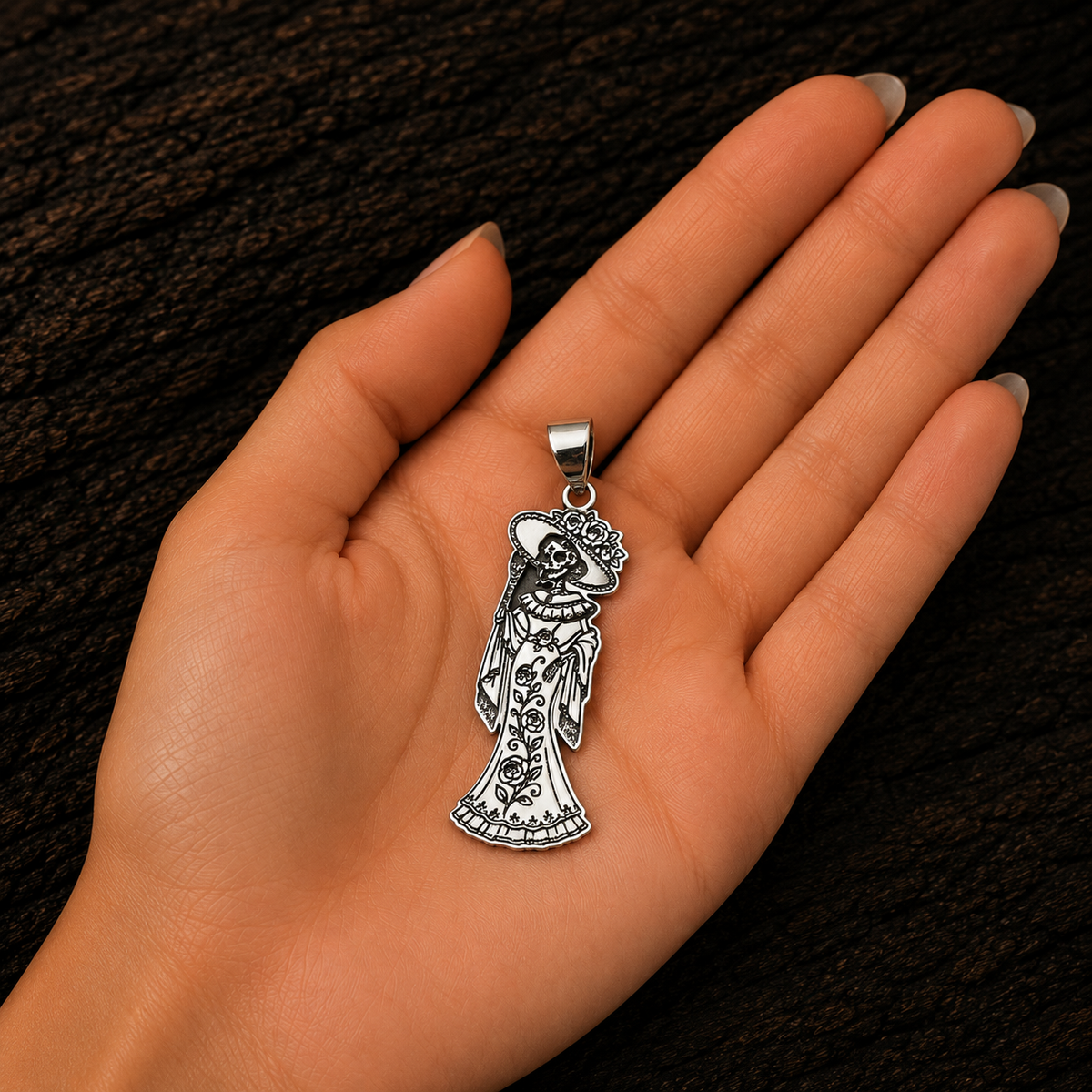 Catrina 925 sterling silver pendant displayed in a woman’s hand to show its size and detailed floral craftsmanship.