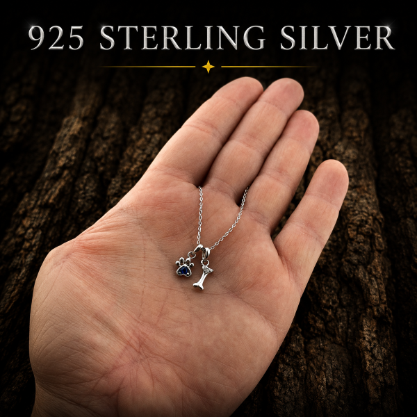 925 Sterling Silver Paw Print and Bone Necklace shown in hand for size reference